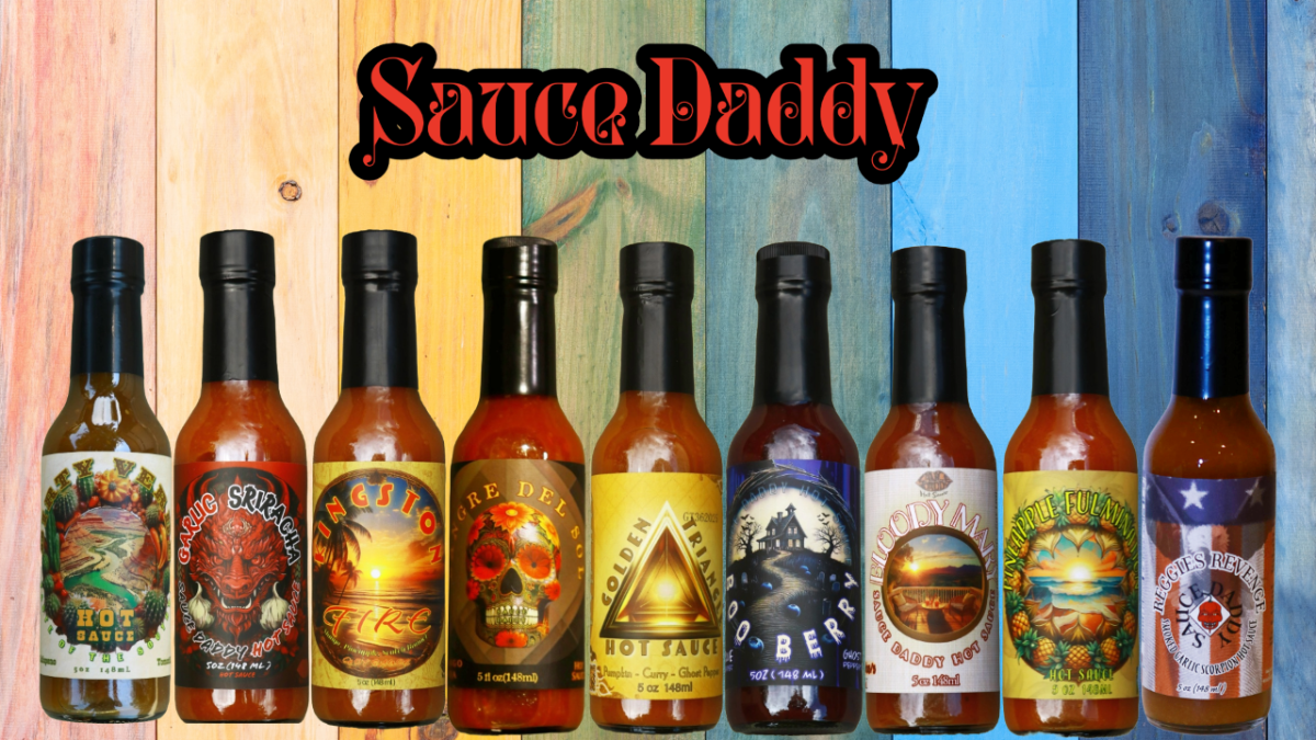 Eight bottles of hot sauce lined up against a rustic wood plank background with the text 'Sauce Daddy' at the top. The bottles feature colorful labels with various fiery and food-themed illustrations, including a dragon, skull, sunset, and compass.